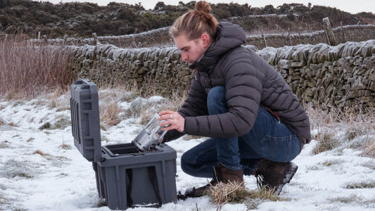 Photo of man using a Direct4x4 expedition storage box in a snowy country field.