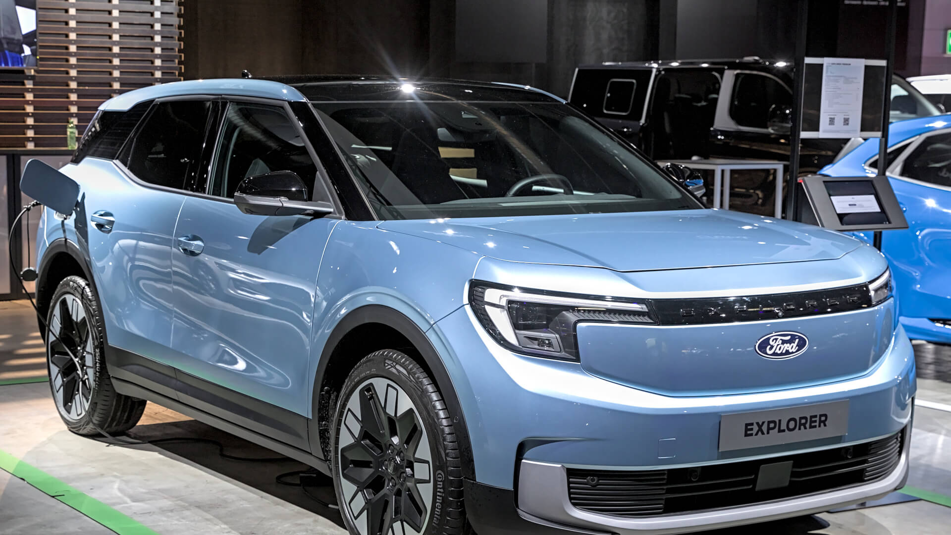 Photo of a blue Ford Explorer EV on charge at a trade show.