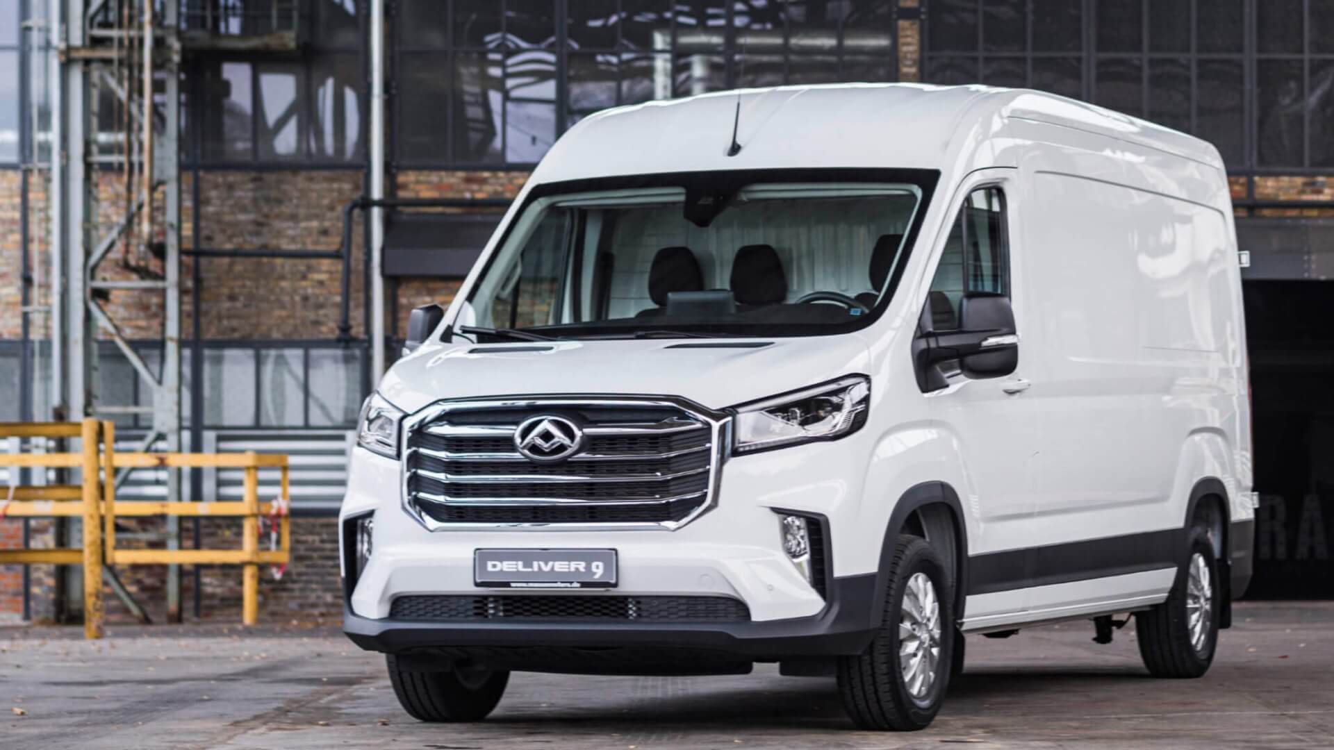 Photo of a white Maxus Deliver van parked in an industrial building parking lot