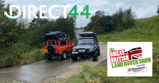 Photo of 2 Land Rovers with Direct4x4 camping gear parked up on a country road next to each other.