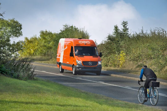 TNT Mercedes Benz delivery van with bicycle on opposite side of the road