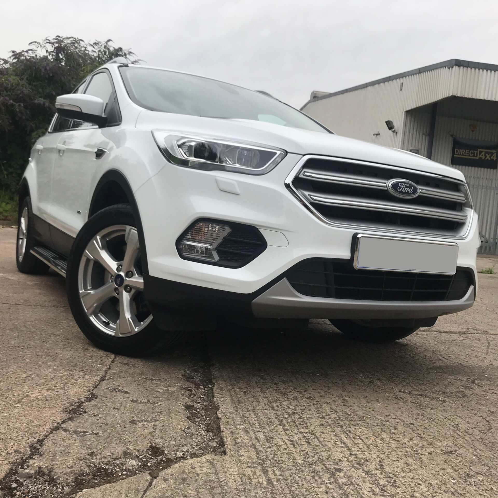 Direct4x4 accessories for Ford Kuga vehicles with a photo of a white Ford Kuga fitted with our premier side steps outside our offices