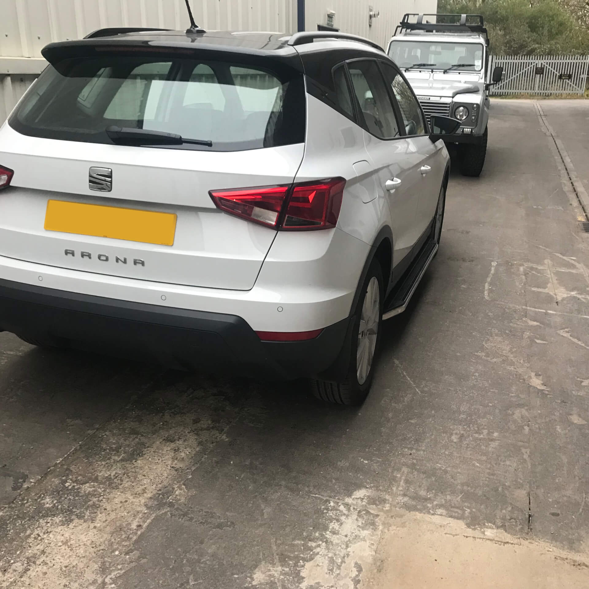 Direct4x4 accessories for Seat Arona vehicles with a photo of a white Seat Arona fitted with Raptor style side steps parked in front of our Land Rover Defender