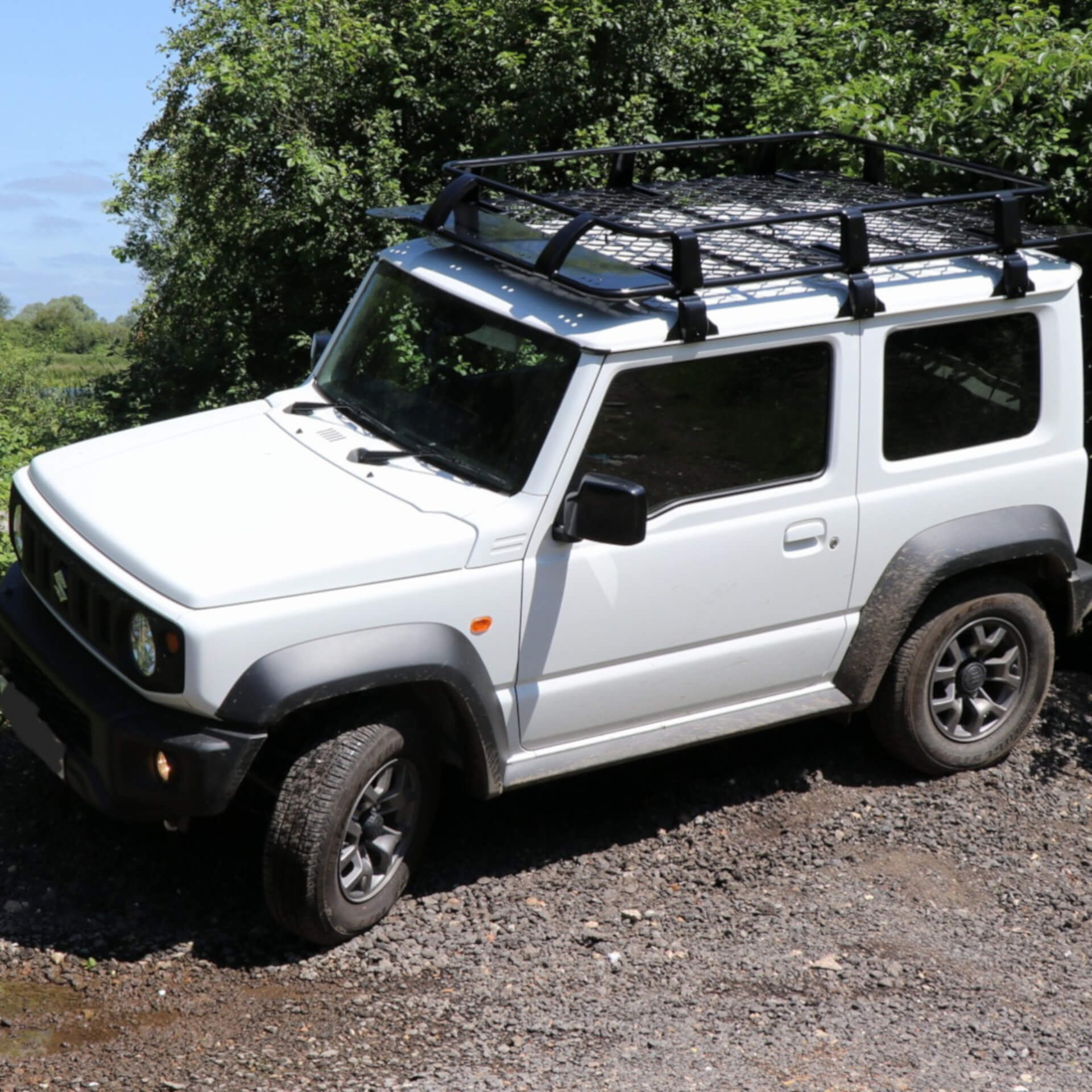 Direct4x4 accessories for Suzuki Jimny vehicles with a photo of a white Suzuki Jimny offroad fitted with a full basket roof rack