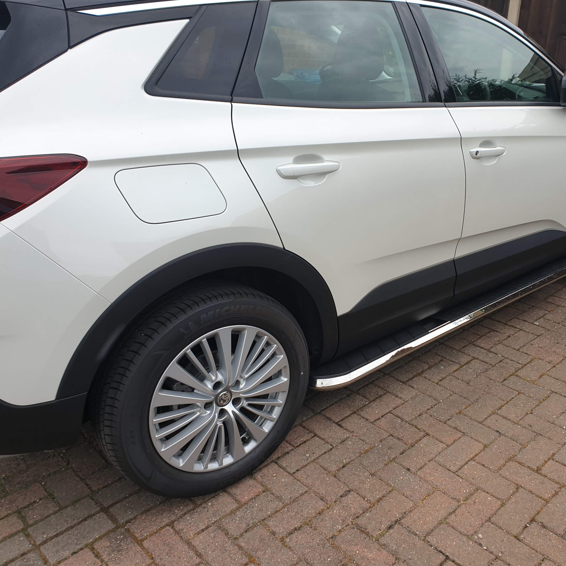 Direct4x4 accessories for Vauxhall Grandland X vehicles with a photo of a white vauxhall grandland x parked on a brick driveway fitted with high flyer style side steps
