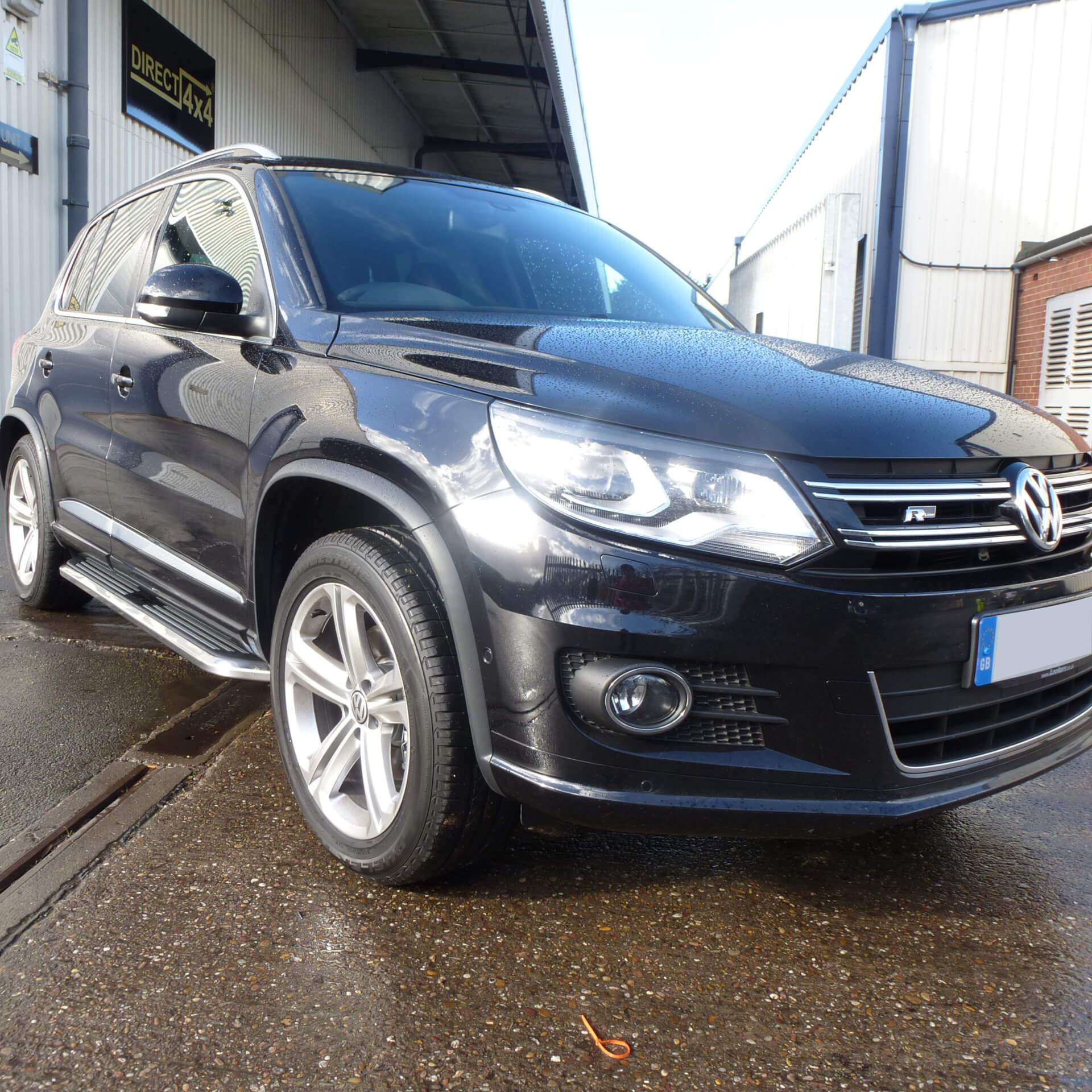 Direct4x4 accessories for Volkswagen Tiguan vehicles with a photo of a black volkswagen tiguan fitted with premier style side steps outside our offices