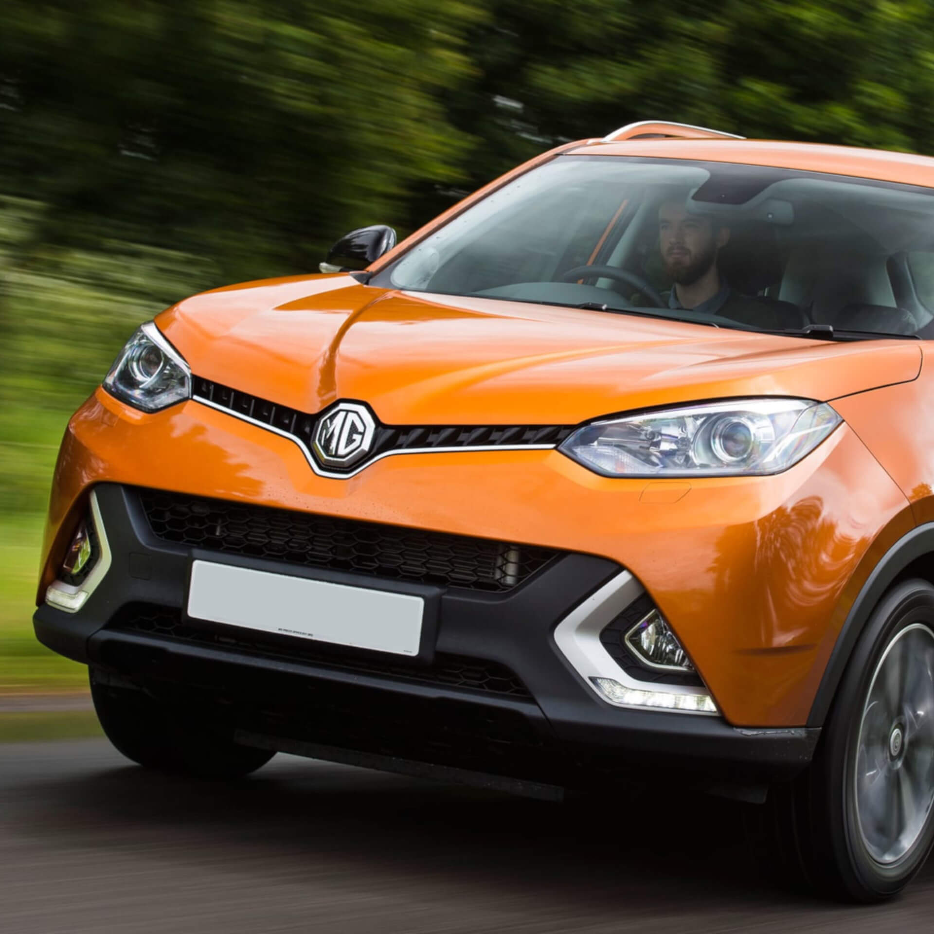 Direct4x4 accessories for MG GS vehicles with a photo of the front of a orange MG GS driving past greenery