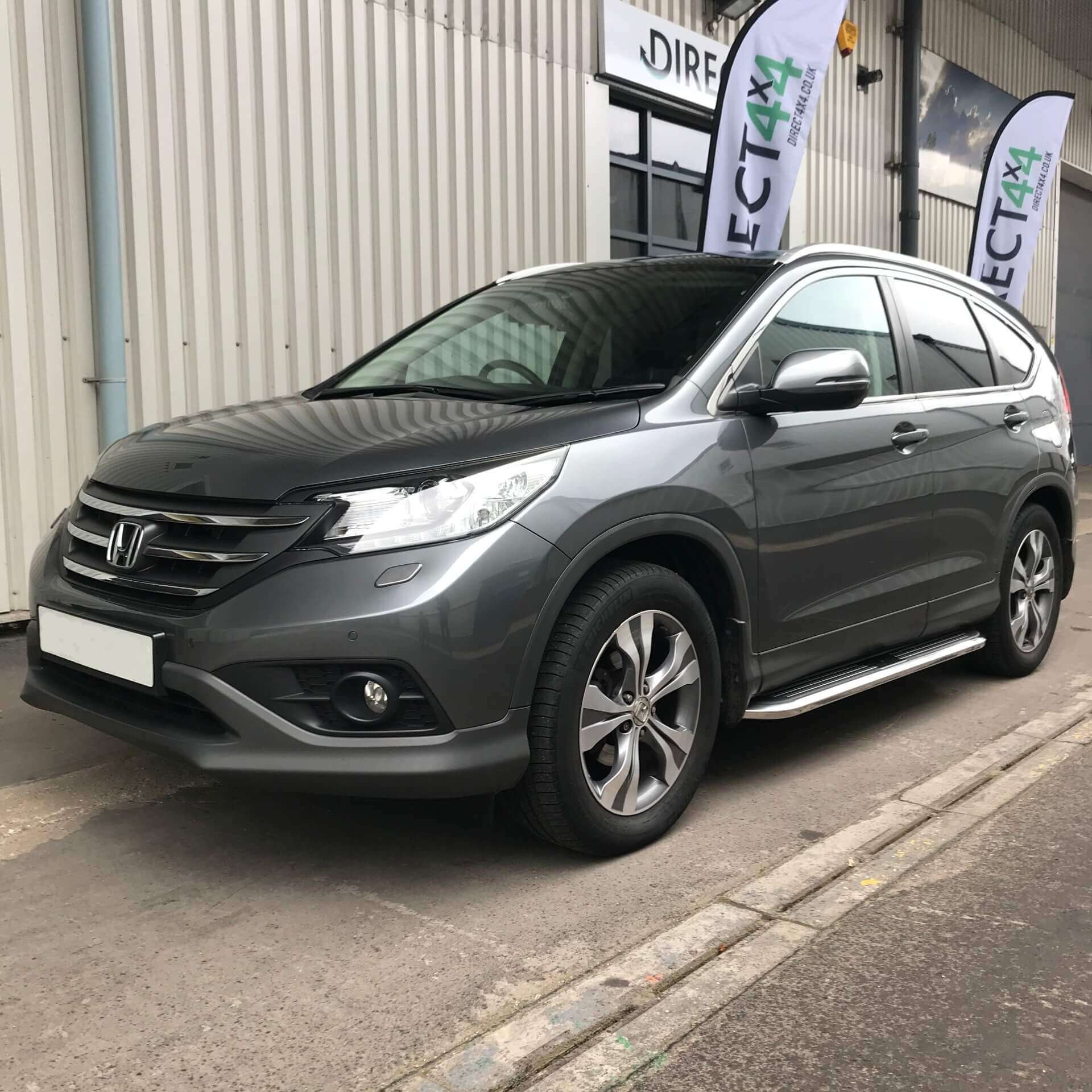 Direct4x4 accessories for Honda CR-V vehicles with a photo of a dark grey Honda CR-V with our premier side steps fitted parked outside our offices