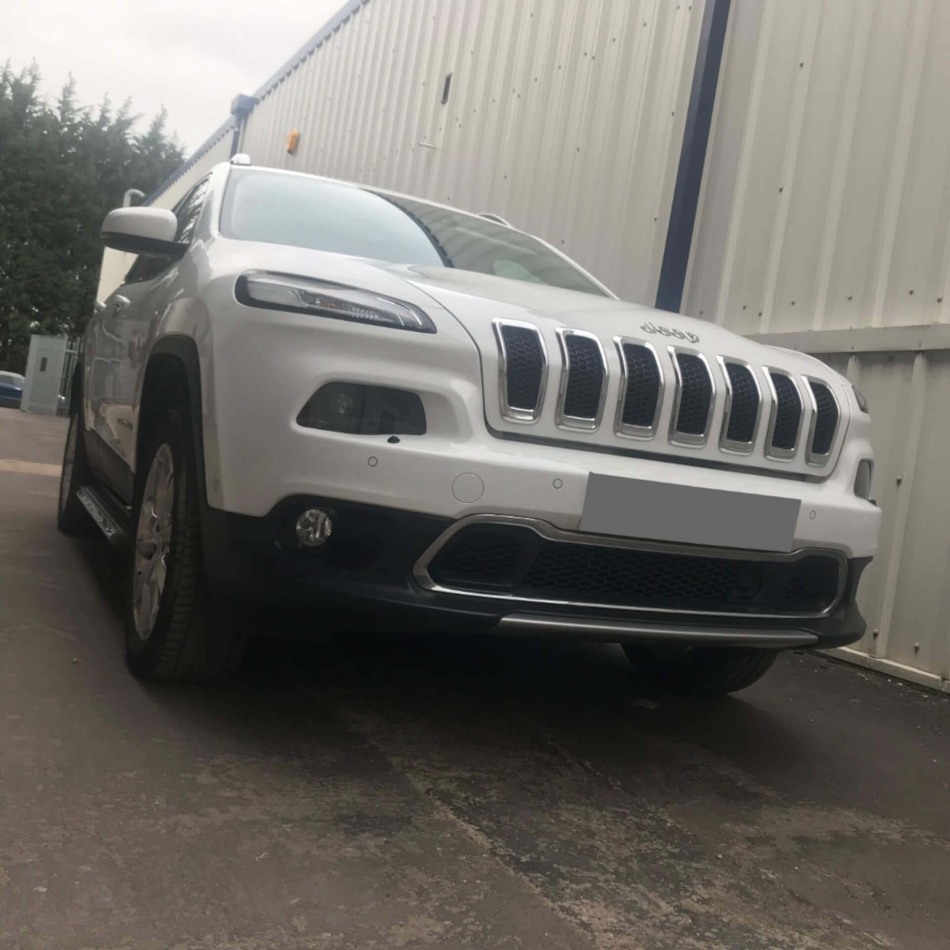 Direct4x4 accessories for Jeep Cherokee vehicles with a photo of a the front of a white Jeep Cherokee parked outside our offices