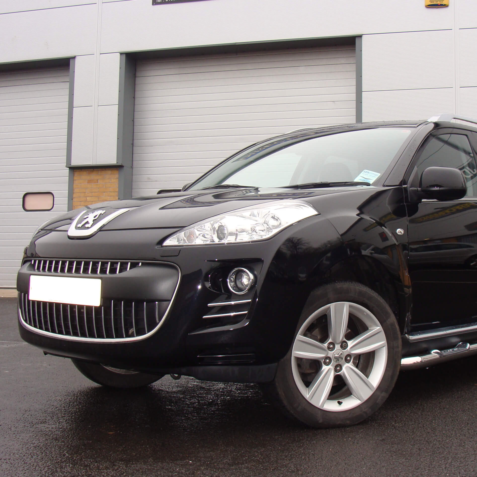 Direct4x4 accessories for Peugeot 4007 vehicles with a photo of a black Peugeot 4007 parked outside a industrial unit