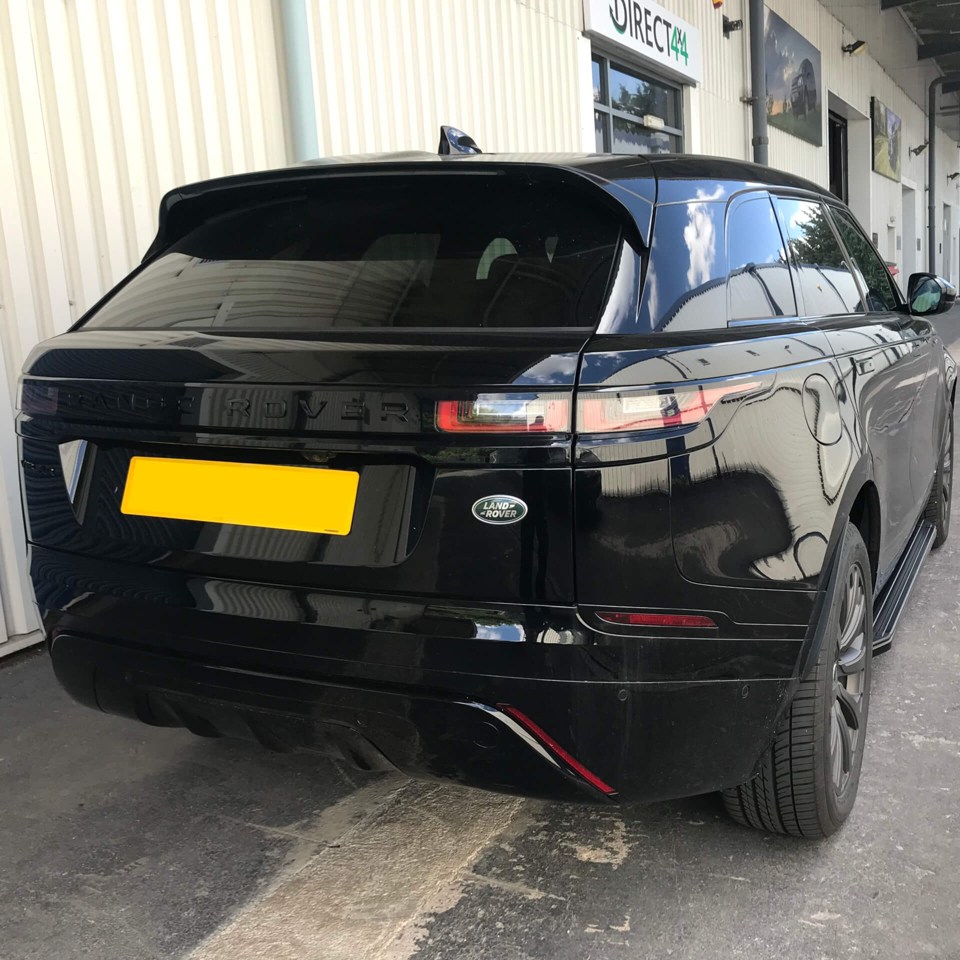 Direct4x4 accessories for Range Rover Velar vehicles with a photo of the back of a black Range Rover Velar fitted with our black raptor side steps outside our offices