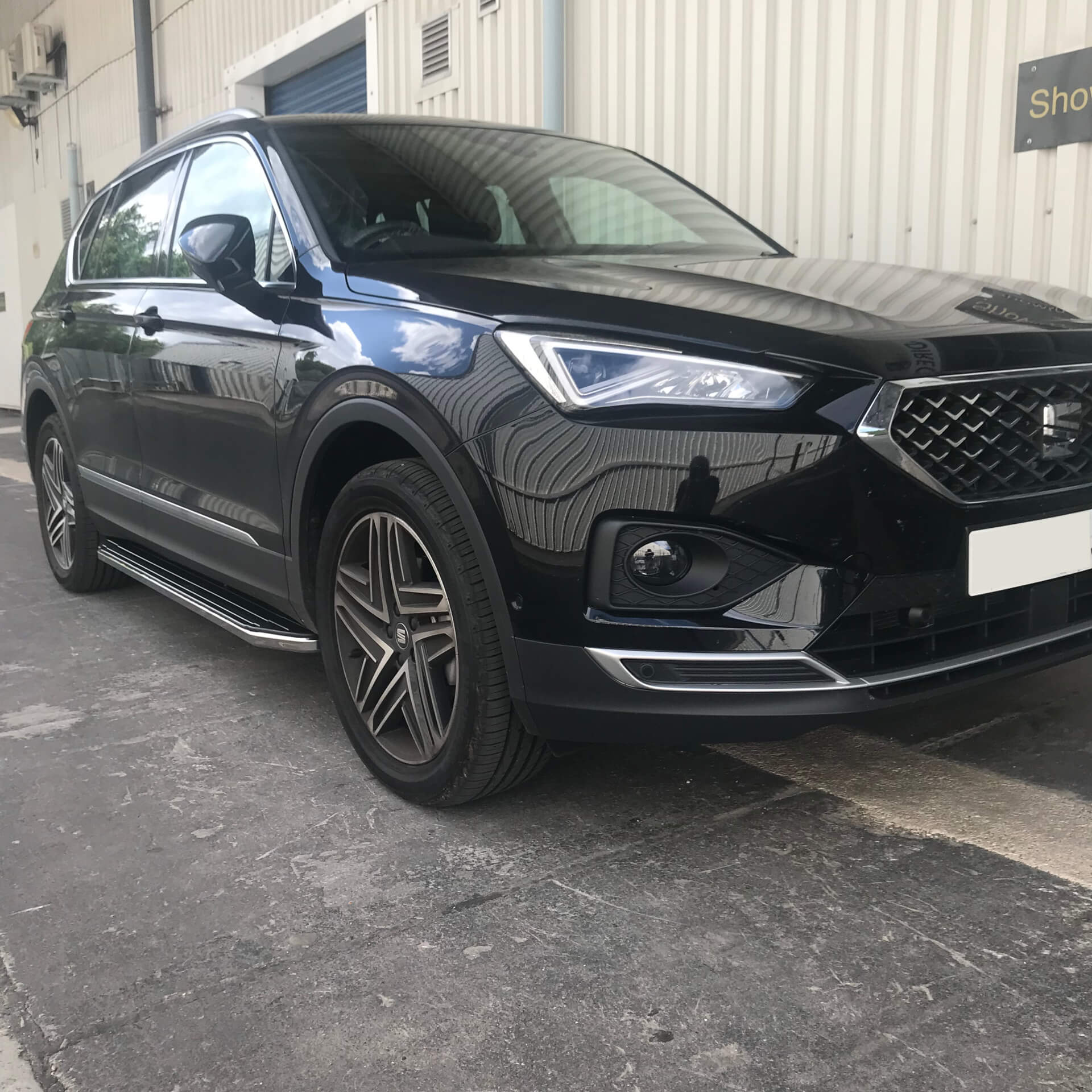 Direct4x4 accessories for Seat Tarraco vehicles with a photo of a black Seat Tarraco parked outside our depot fitted with raptor style side steps
