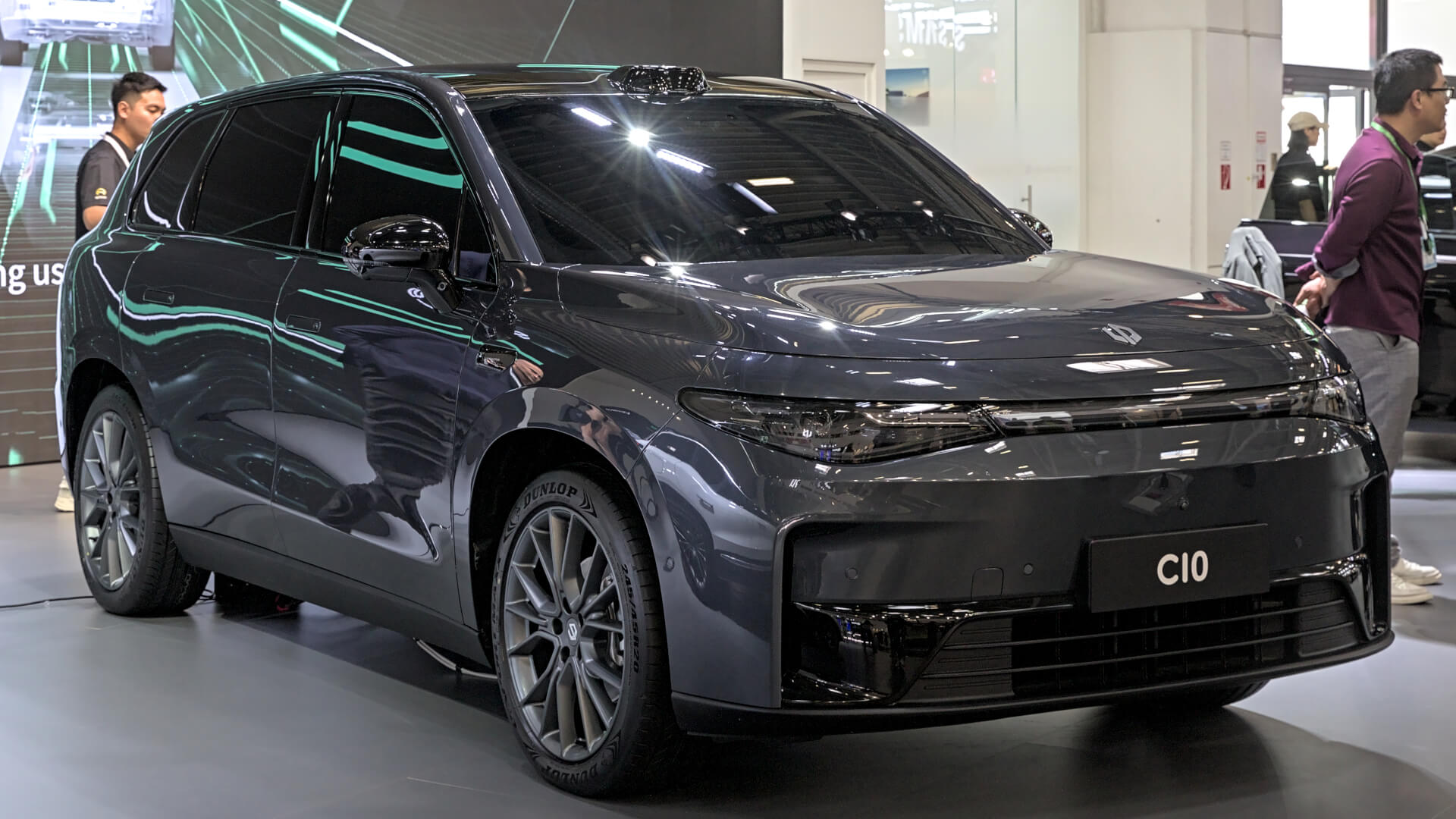 Photo of a dark grey Leapmotor C10 electric SUV vehicle in a showroom with people around it