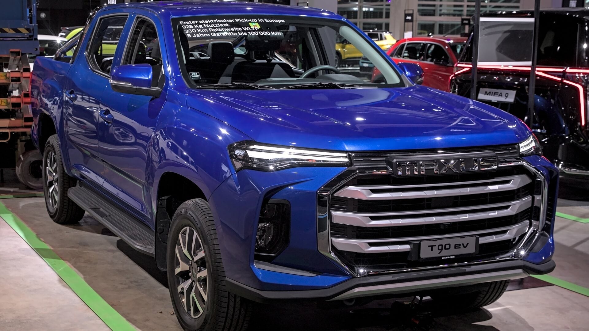 Photo of a blue Maxus T90 pickup truck on display at a European motor show