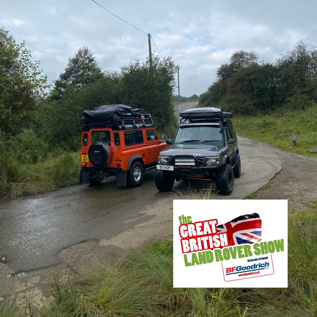 Photo of an orange Land Rover Defender 90 and a Discovery 2 with Direct4x4 expedition gear fitted on a country road.