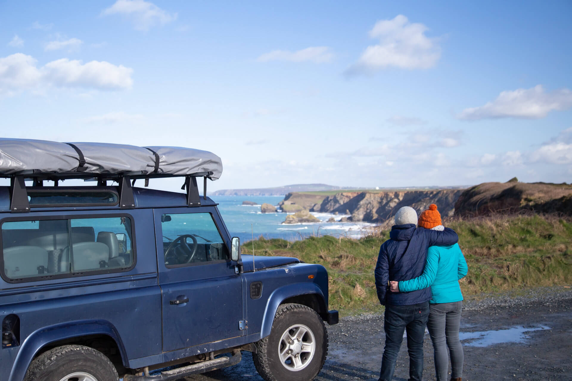 Direct4x4 Black Friday and Cyber Monday weekend deals and discounts with a blue Land Rover Defender parked up in front of the beach